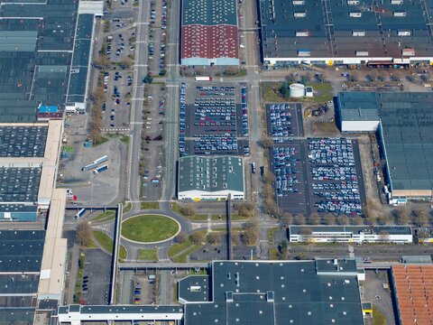 Aerial view of the stark geometric patterns of industrial buildings and car parks create a mesmerizing urban landscape, a blend of human activity and architectural design, Sausheim, Grand Est, France.