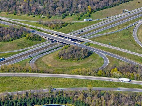 Aerial view of a sprawling highway interchange cutting through verdant fields and forests, the concrete and asphalt contrasting with nature's palette, Sausheim, Grand Est, France.