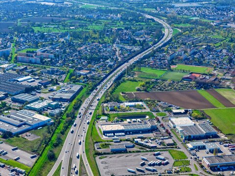 Aerial view of a major freeway cutting through urban and rural landscapes, a dance of concrete and green, Sausheim, Grand Est, France.