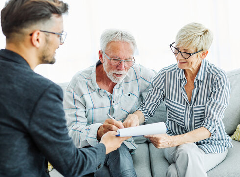 Happy senior old family couple clients make financial insurance estate business deal contract signing, agent lawyer, satisfied mature customers sogning contract meeting bank manager agree on investmen