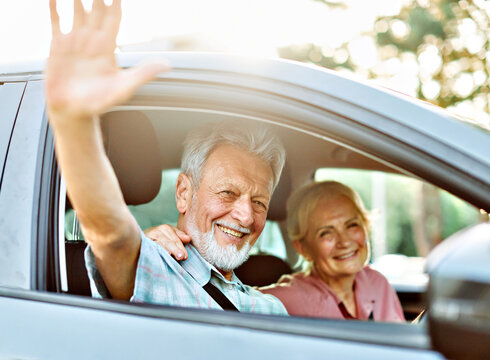 Happy senior couple going on a trip in their car