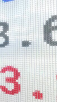 Vertical video: Hand cam starting on plus panning LED revealing gray-red digits for pixel detail