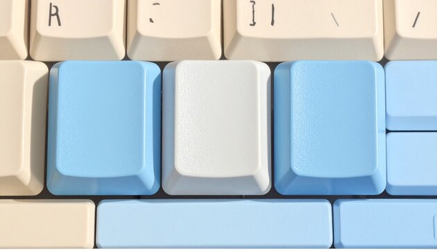 "A close-up of a computer keyboard with mostly white keys, featuring one cream-colored key and two adjacent bright blue keys, symbolizing customization, contrast, and aesthetic modification."