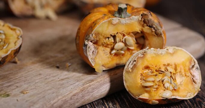 Vegetable decays in studio pumpkin , decaying orange vegetable with white mold and wet pulp on a wooden background with sharp details of organic surface and authentic look.