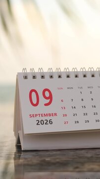 Slow motion footage of flip calendar pages for change months from august to september of the year 2026. concept of planning and starting a new month. 4k vertical.