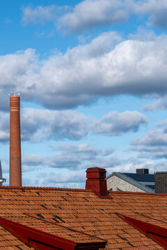 Minimal modern architecture building facade skyline cityscape showing heritage rooftop tiles and chimney forms under pale sky clouds background with quiet atmosphere