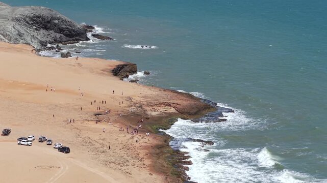 Breathtaking drone footage of Playa Arcoiris in Cabo de la Vela, Colombia. Marvel at the stunning contrast between golden sands and the azure sea under clear skies.