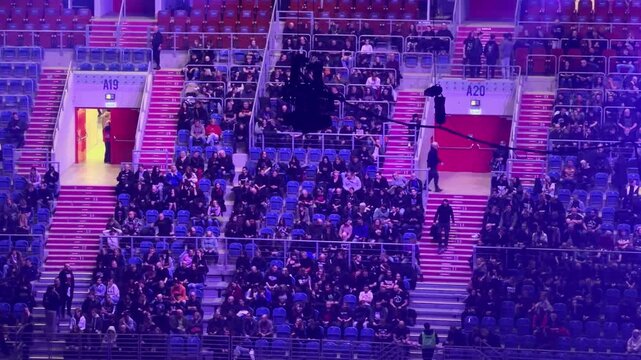 Krakow, Poland - December 1, 2025: Enthusiastic audience fills stadium seats near sections A19 and A20, illuminated by vibrant purple lighting during an exciting live event