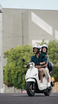 Video of beautiful and happy couple riding around the city on a motorbike