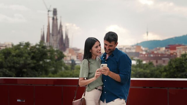 Video of beautiful couple taking photos of themselves with smartphone in the city