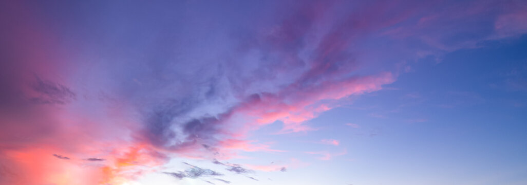 Panoramic sunset sky with soft pink and purple twilight clouds.