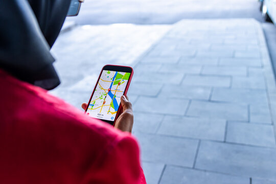 Latin woman using navigation app on smartphone while traveling
