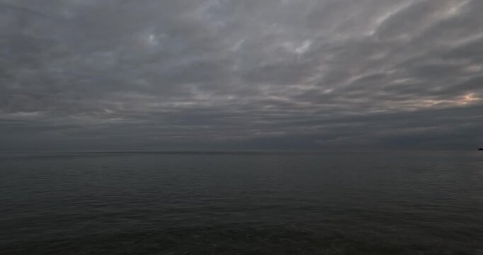 Ocean horizon clouds under a dramatic overcast sky during a calm evening at the beach
