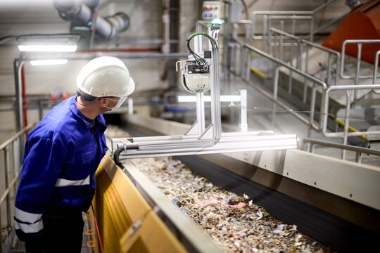 Industrial staff member observing material flow in RDF manufacturing operation.