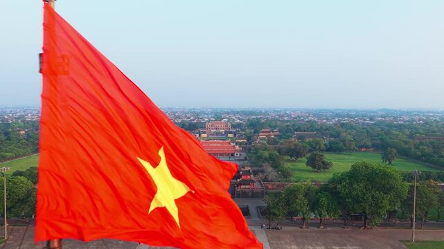 Vietnam flag flying about Imperial City of Hue - Aerial drone reveal of historic citadel