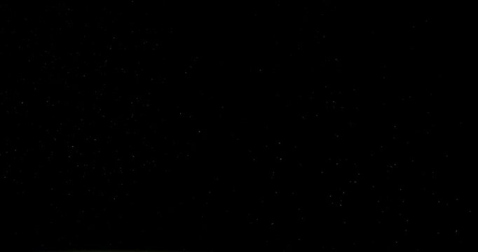 Super slow motion (1000 fps) floating dust particles in the air, isolated on black background. Cinematic atmospheric shot with soft light, depth and abstract texture.