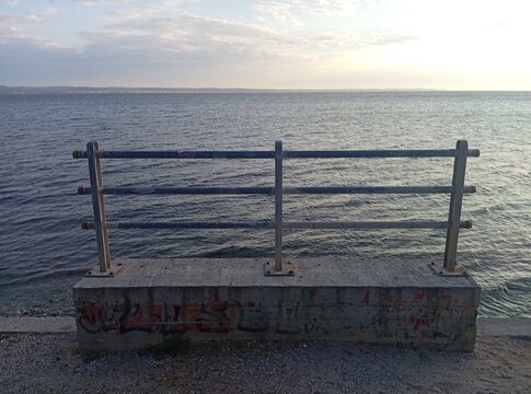 Railing with lines against the open sea in Nea Krini, Thessaloniki, Greece