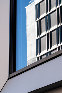 Modern urban architecture at a sharp corner facade with glass window grid and minimal lines creating a calm structured look