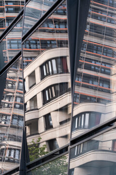 Curves and lines in a glass facade with modern urban building architecture and window reflection creating a refined city surface