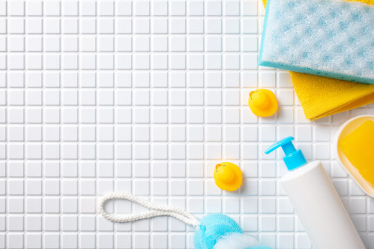 Modern bathroom essentials and body care products arranged on white mosaic tile background