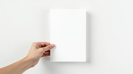 Obraz premium Maqueta de una mano sosteniendo una hoja de papel A4 en blanco, ángulo recto, fondo blanco limpio