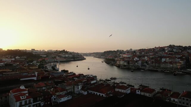 Ribeira district and Douro River in Porto municipality Porto district Norte region Portugal with Dom Luis I Bridge and Vila Nova de Gaia waterfront, lateral pan right drone aerial shot