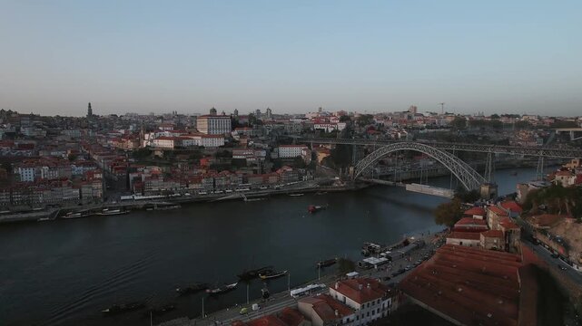 Dom Luis I Bridge and Douro River in Porto municipality Porto district Norte region Portugal with Porto and Vila Nova de Gaia riverfront, drone orbit with tilt down revealing city