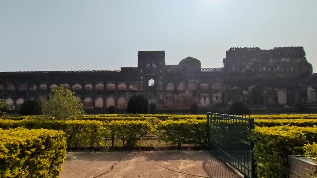Hazar Kothri side wall with sun and garden trees at bidar fort, karnataka, india. day time, push back shot, 4k.