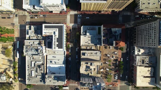 Drone flying north above 5th Street at 9AM capturing rooftops and cars moving through downtown San Diego.
