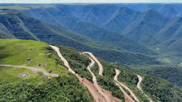Mountain road aerial view with visible final construction works on steep slopes in Serra da Rocinha, Brazil.