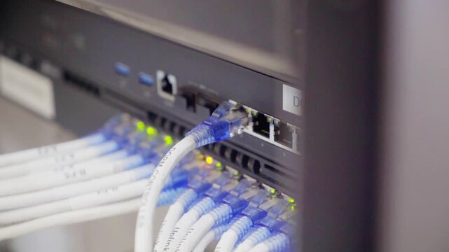Professional office network hub and patch panel hardware with digital data cables connected to an electronic switch for business internet communication technology
