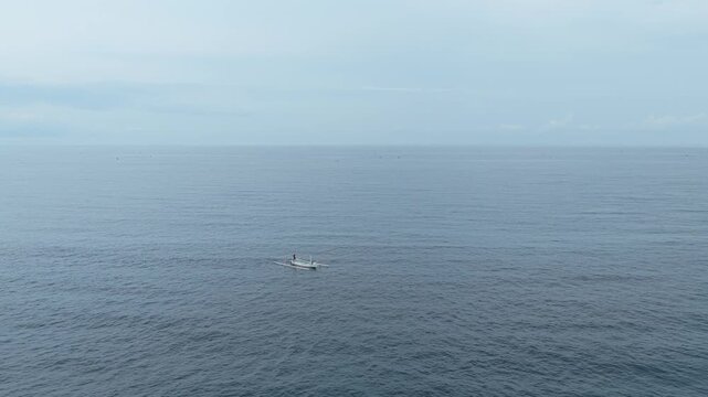 Balinese fisherman paddling traditional jukung boat in amed sea