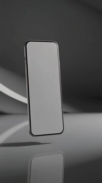 A sleek smartphone with a blank screen stands on a reflective surface against a dark background with neon light