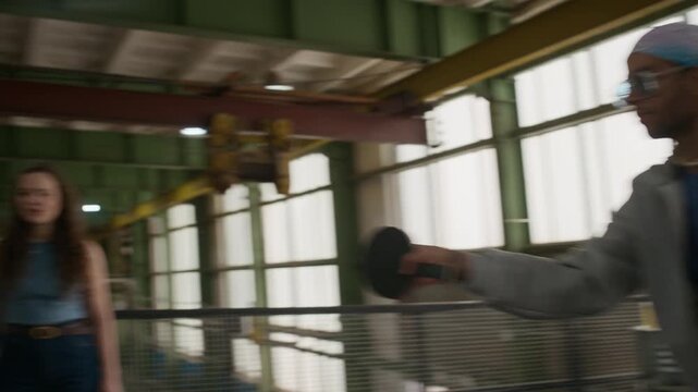 Tracking side to side shot of young friends playing ping pong, exchanging shots smoothly across table without errors during fun indoor activity