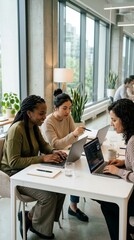Obraz premium Diverse women collaborating on laptops in a modern office
