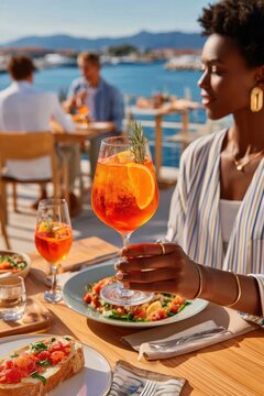 Woman enjoying an Aperol Spritz at a seaside outdoor lunch with fresh bruschetta and salad