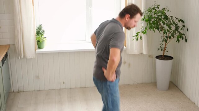 Handsome bearded man dance, have fun at home listens song, moves to music, feels overjoyed, celebrate good news, relish carefree life looks happy. Young adult male twirls, grooves, dancing in kitchen