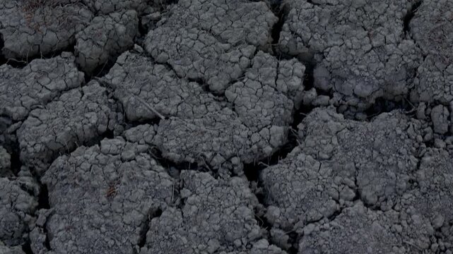 The camera moves over the dry, cracked earth. Climate change