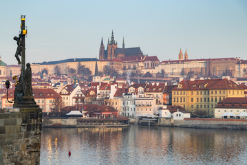 Fototapeta premium scenic view of Prague Castle and Charles Bridge glowing in golden light over the Vltava River