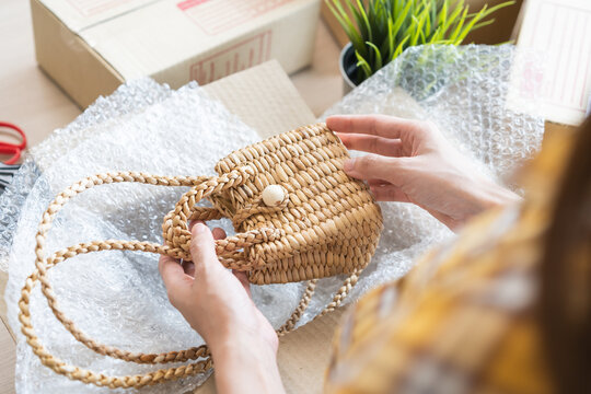 Online seller store, small business entrepreneur asian young woman, girl hand packing order product package, craft bag in box at home office, preparing pack parcel sent to delivery company to customer