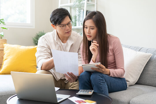 Stressed financial owe asian young couple love sitting suffer, stressed and confused by calculate expense from invoice or bill, no money to pay, mortgage or loan. Debt, bankrupt or bankruptcy people.