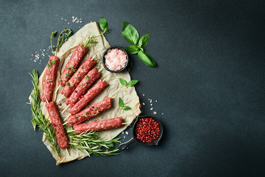 Raw Lyulya kebab with spices and herbs, ready for cooking. On a dark stone background. Top view....