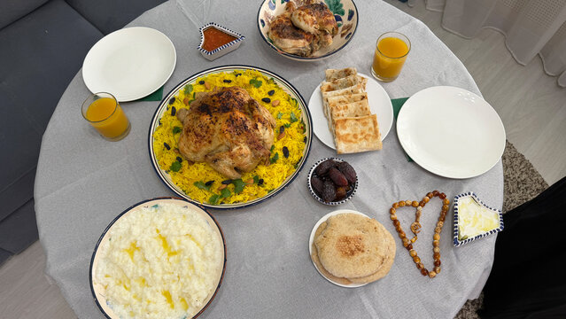 Top view of Saudi traditional food including Kabsa rice, Saleeg, Mutabbaq and dates served during Ramadan Iftar.