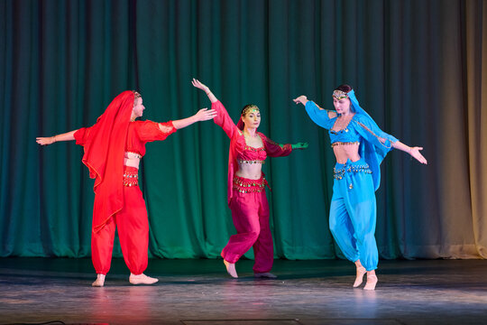 Vibrant odalisque dance performance with red and blue costumes on stage