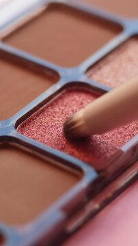 Close-up vertical footage of brush dipping into nude eyeshadow palette, minimal composition and warm tones. Perfect for fashion, beauty concepts and lifestyle visuals