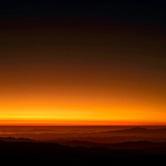 Obraz premium Golden Hour Sunrise Over Mountain Ranges with Bright Orange Sky
