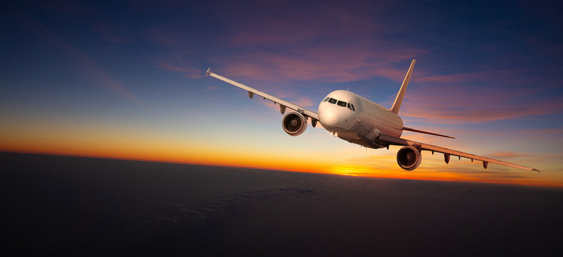 Commercial airplane flying during sunset with dramatic sky