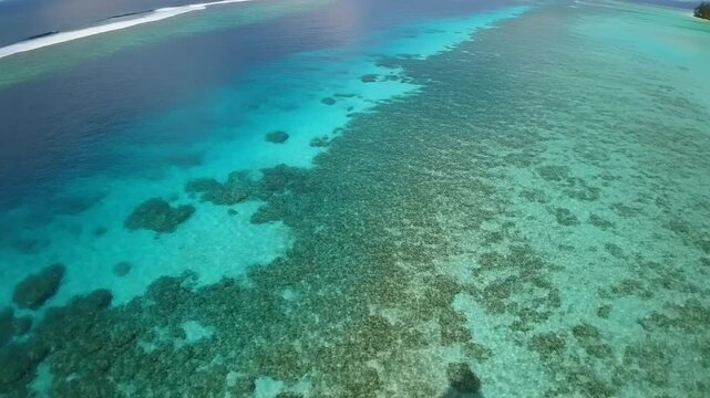 FPV drone gliding low over turquoise lagoon waters in Bora Bora, coral patterns visible
