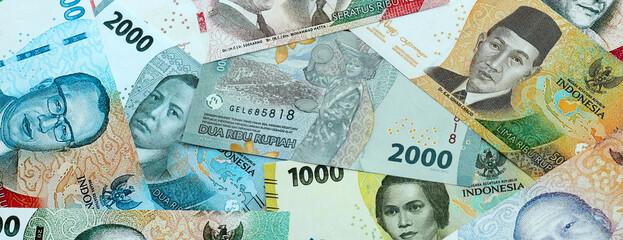 Indonesian rupiah money banknotes pile on table. Indonesia bills of IDR currency close up © Larysa