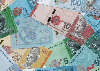 Malaysian ringgit money banknotes pile on table. Malaysia bills of MYR currency close up © Larysa